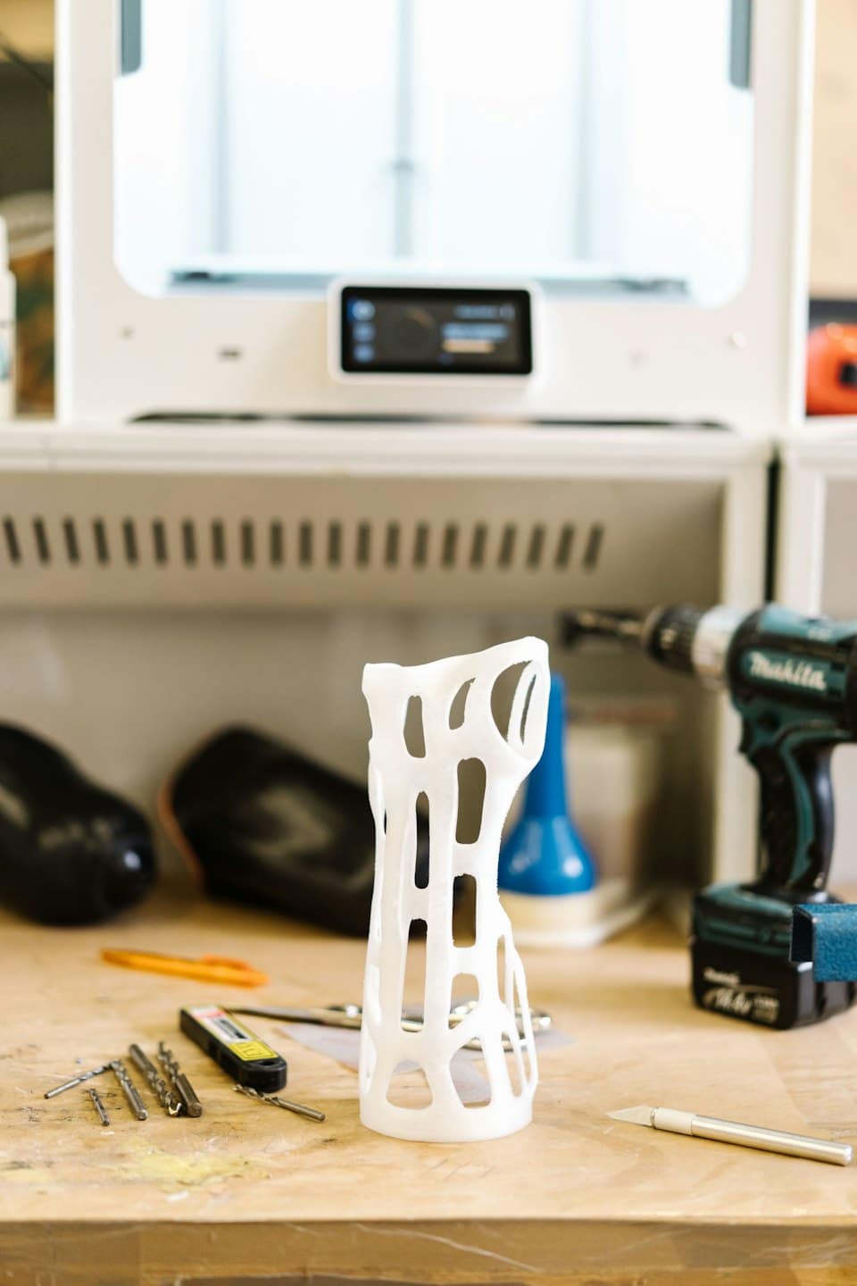 3D-printad ortopedisk protes på en arbetsbänk med verktyg.