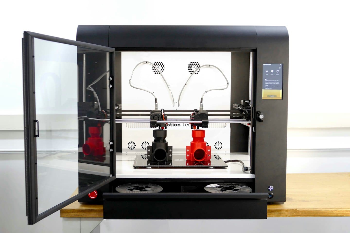 Svart industriell 3D-skrivare med öppen dörr i verkstad.